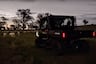 Can-Am Defender parked at sunset in front of farm animals